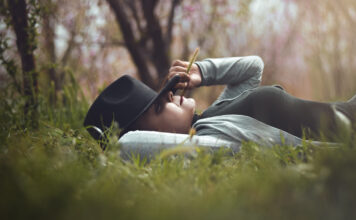 5 Tipps für erholsamen Schlaf Eine Frau erholt sich schlafend im Freien