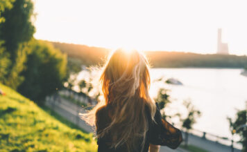 Junge Frau sitzt im Sommer draussen