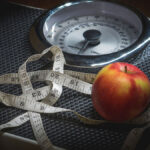 Messband, Waage und ein Apfel - wie der Stoffwechsel das Gewicht beeinflusst