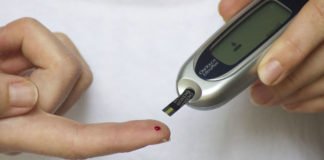Blutzucker wird mit einem Messgerät am Finger gemessen