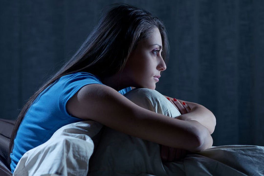 Frau kann wegen Schlafstörungen im Bett nicht schlafen