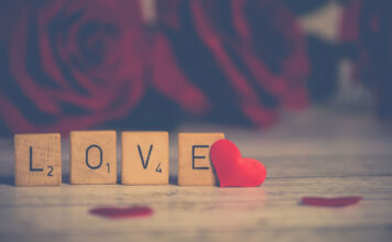 Stressabbau und Prävention im gemeinsamen Schlafzimmer Rosen und scrabble Steine mit dem Wort Love