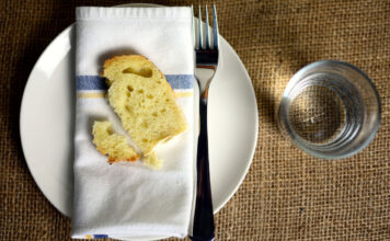 Fasten – was ist das eigentlich und welche Formen gibt es? Ein Stück Brot auf dem Teller als Symbol von Fasten