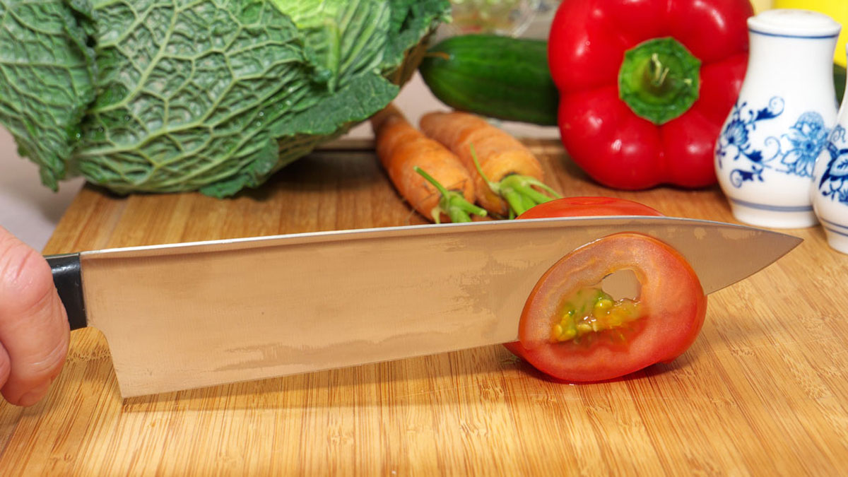 Mit scharfem Messer Tomate schneiden