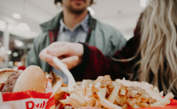 Abnehmen: So kannst Du Heißhunger und Fressattacken stoppen Eine Frau isst mit Heißhunger Fastfood