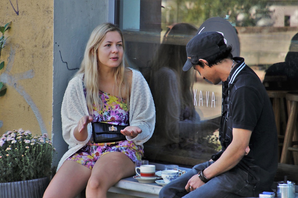Zwei junge Leute unterhalten sich in einem Strassencafe