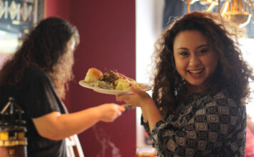 Eine Frau betrachtet ihre Mahlzeit als Glücklichmacher