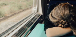 Eine Frau hat Schlafmangel im Zug
