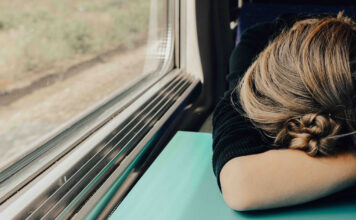 Eine Frau hat Schlafmangel im Zug