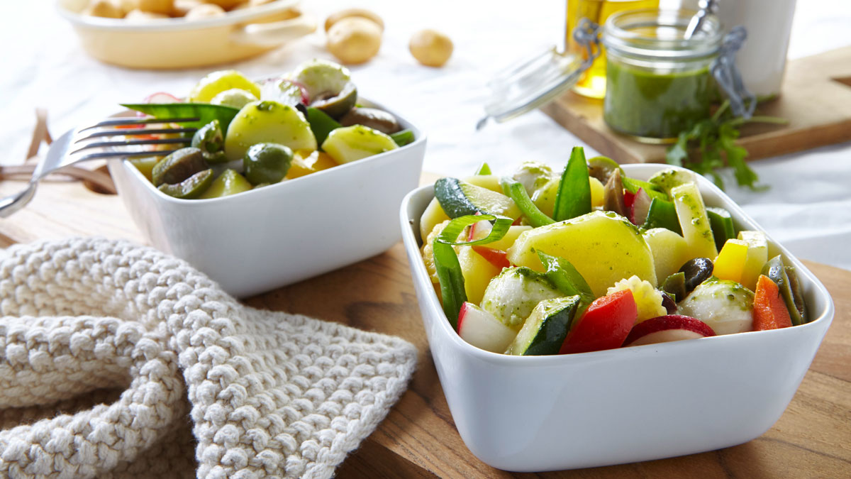 Mediterraner Kartoffelsalat mit Rucolapesto auf dem Esstisch für den Frühlingsstart in die leichte Küche
