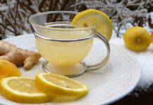 Zitronentee und Ingwer auf einem Teller, der auf einem schneebedeckten Tisch steht