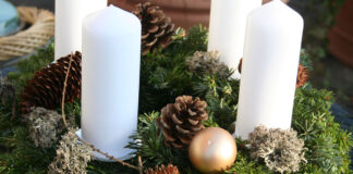 Ein Adventskranz mit Tannenzweigen und vier weissen Kerzen