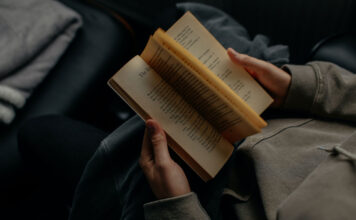 Eine Frau liest auf Grund von Buchempfehlungen im Bett ein Buch