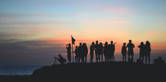 Eine Gruppe von Menschen beobachten den Sonnenaufgang.