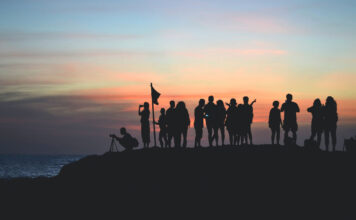 Eine Gruppe von Menschen beobachten den Sonnenaufgang.
